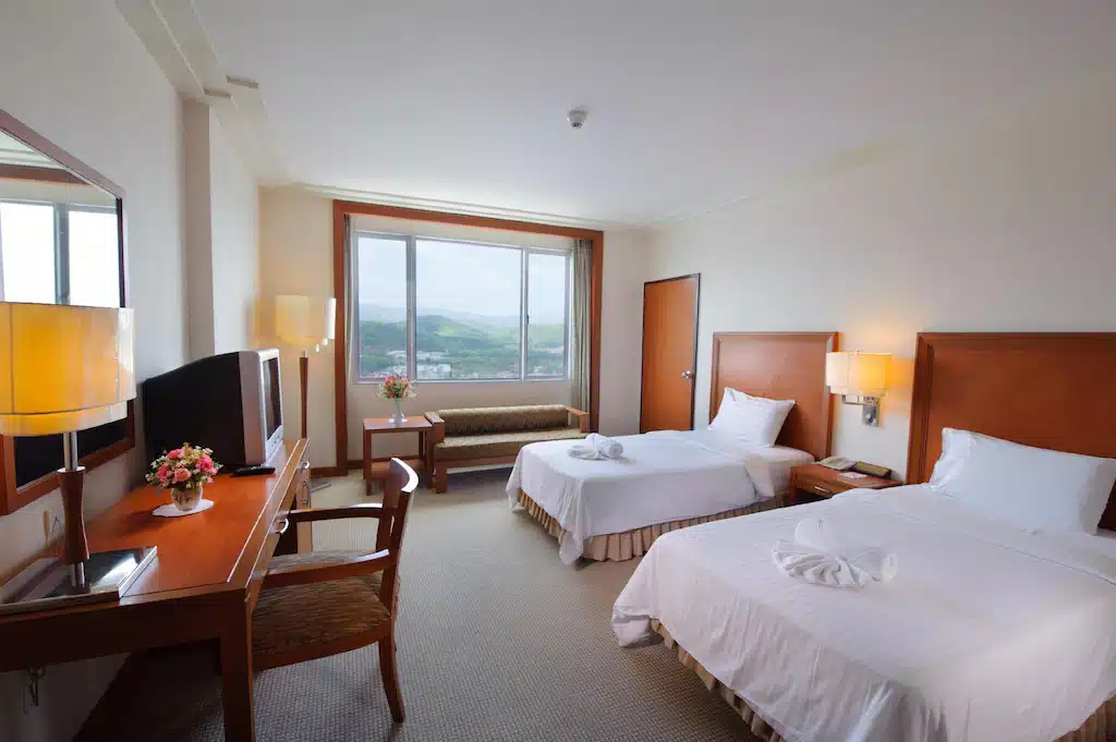 ห้องพักในโรงแรมที่มีเตียง 2 เตียงและโต๊ะทานอาหารทะเลหมอกเบตง  ที่พักทะเลหมอกเบตง