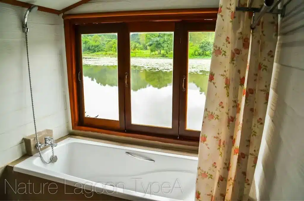 ห้องน้ำพร้อมอ่างอาบน้ำและหน้าต่างมองเห็นทะเลสาบในพื้นที่ท่องเที่ยวน่าน สังขละบุรีที่พัก