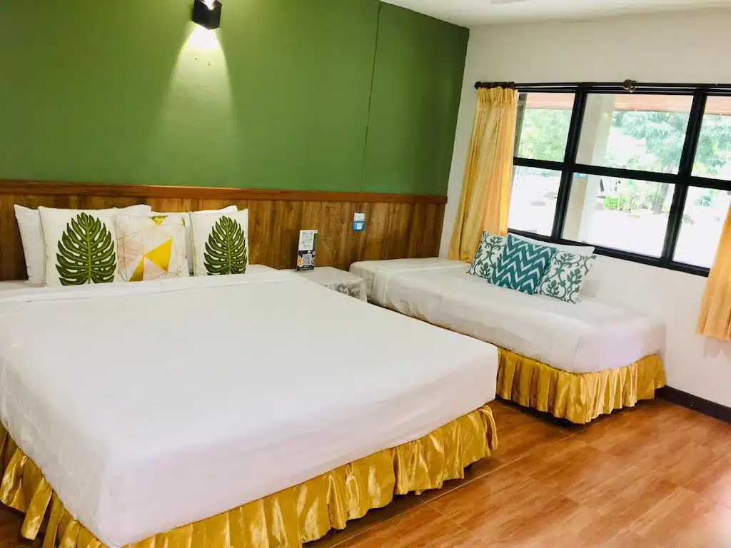 ห้องที่มีสองเตียงและผนังทาสีเขียว รีสอร์ทสุรินทร์
