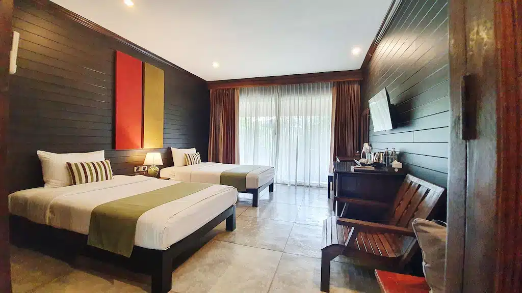 ห้องที่มีเตียงสองเตียงและโทรทัศน์ในสถานที่ท่องเที่ยวยอดนิยม สังขละบุรีที่พัก