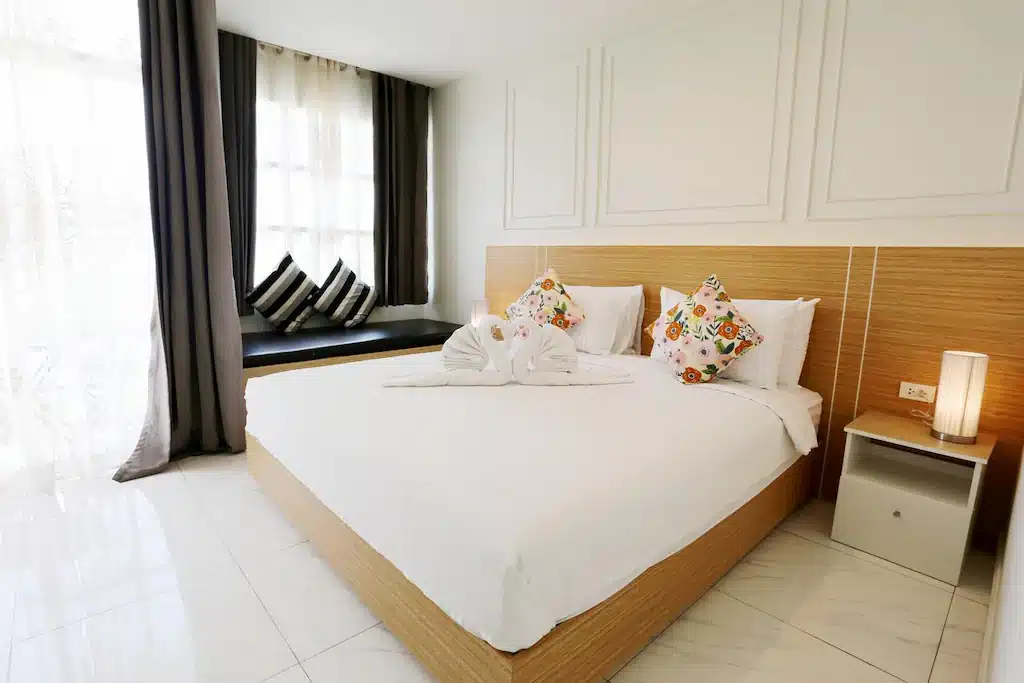 ห้องนอนพร้อมเตียงสีขาวและผ้าเช็ดตัวสีขาวในเที่ยวน่าน ที่พักปัว