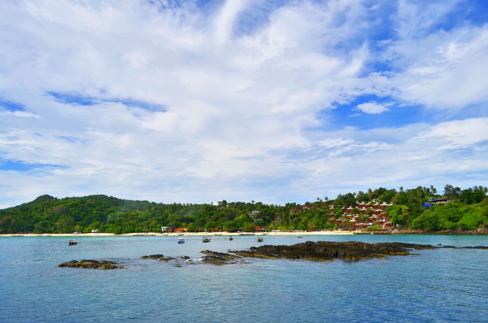 ชายหาดที่มีบ้านเรือนไม่กี่หลังและท้องฟ้าแจ่มใสในเชียงคาน เกาะพีพี