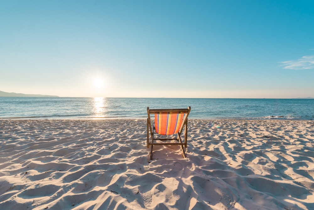 เก้าอี้ชายหาดนั่งอยู่บนผืนทรายยามพระอาทิตย์ตกดิน ทะเลใกล้กรุงเทพไปเช้าเย็นกลับ
