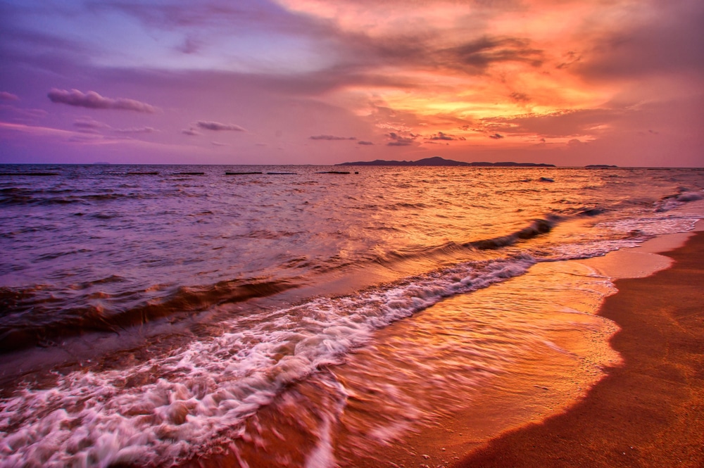 ชายหาดที่มีคลื่นและพระอาทิตย์ตก เที่ยวทะเลใกล้กรุงเทพ