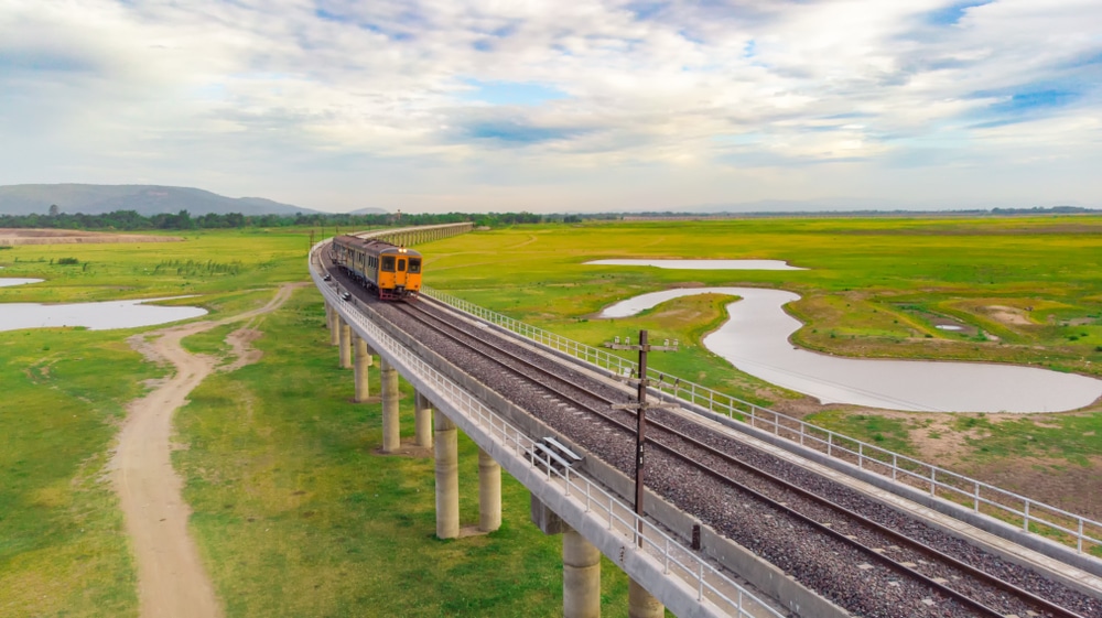มุมมองทางอากาศของรถไฟที่กำลังวิ่งข้ามสะพาน ที่เที่ยวลพบุรี