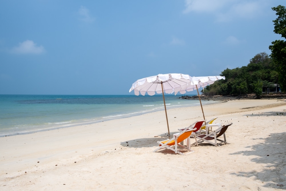 ชายหาดที่มีเก้าอี้และร่มบนผืนทราย เที่ยวทะเลใกล้กรุงเทพ