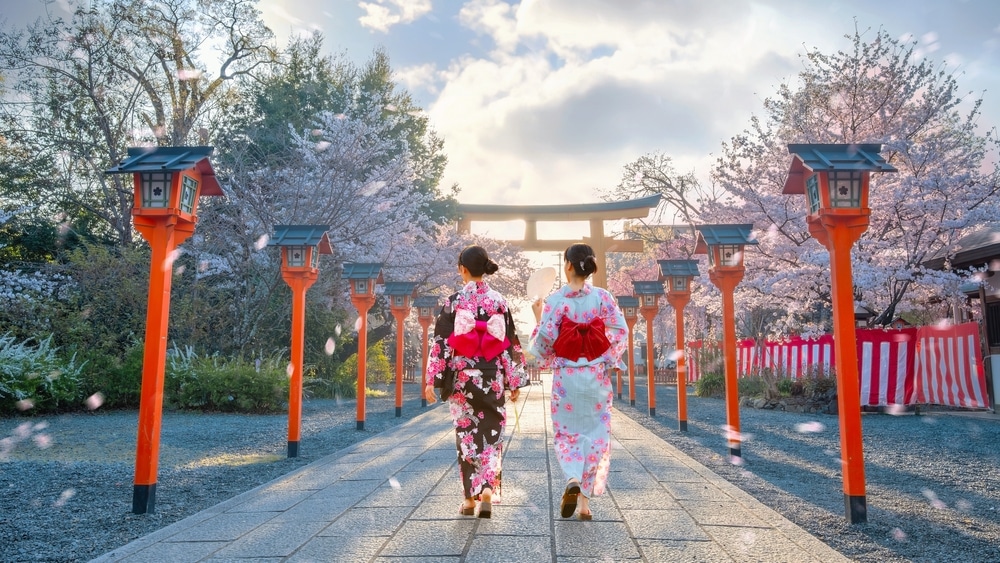 ผู้หญิงญี่ปุ่นสองคนเดินผ่านประตูโทริอิในญี่ปุ่น สถานที่ท่องเที่ยวญี่ปุ่น