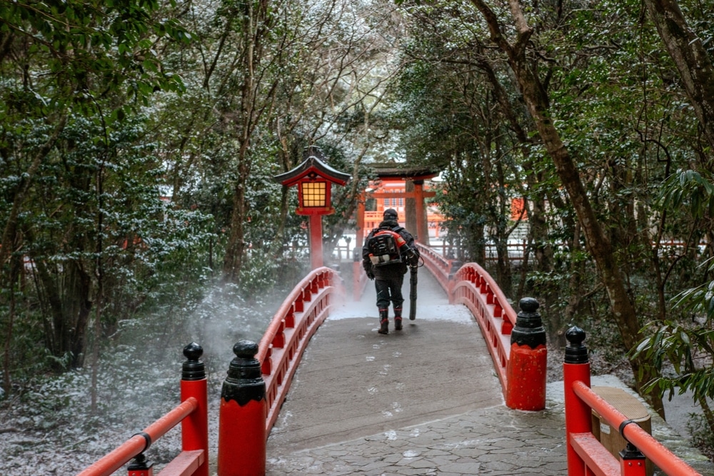 คนเดินข้ามสะพานสีแดงกลางหิมะที่จุดท่องเที่ยวในญี่ปุ่น เที่ยวญี่ปุ่น