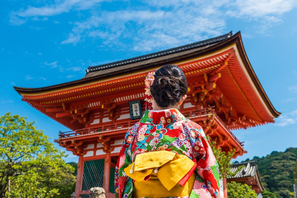 ผู้หญิงในชุดกิโมโนยืนอยู่หน้าเจดีย์ ซึ่งเป็นสถานที่ท่องเที่ยวในญี่ปุ่น เที่ยวญี่ปุ่นด้วยตัวเอง