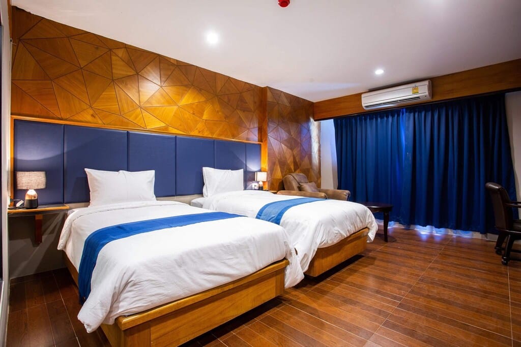 ห้องพักในโรงแรมทันสมัยพร้อมเตียงแฝด 2 เตียง ตกแต่งด้วยสีฟ้า และผนังไม้ เที่ยวสกลนคร