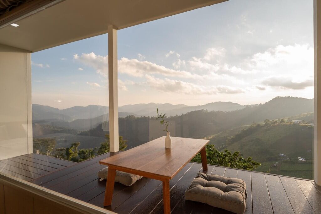 บ้านมองเห็นวิวภูเขาพร้อมโต๊ะและเก้าอี้ ที่เที่ยวแม่ริม