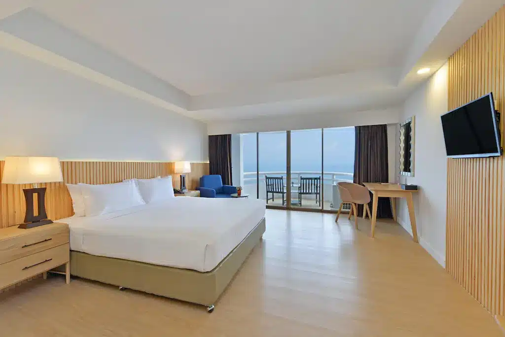 ห้องพักในโรงแรมทันสมัยพร้อมเตียงขนาดใหญ่ วิวทะเล โต๊ะทำงาน และทีวีจอแบนที่ โรงแรมหาดจอมเทียน