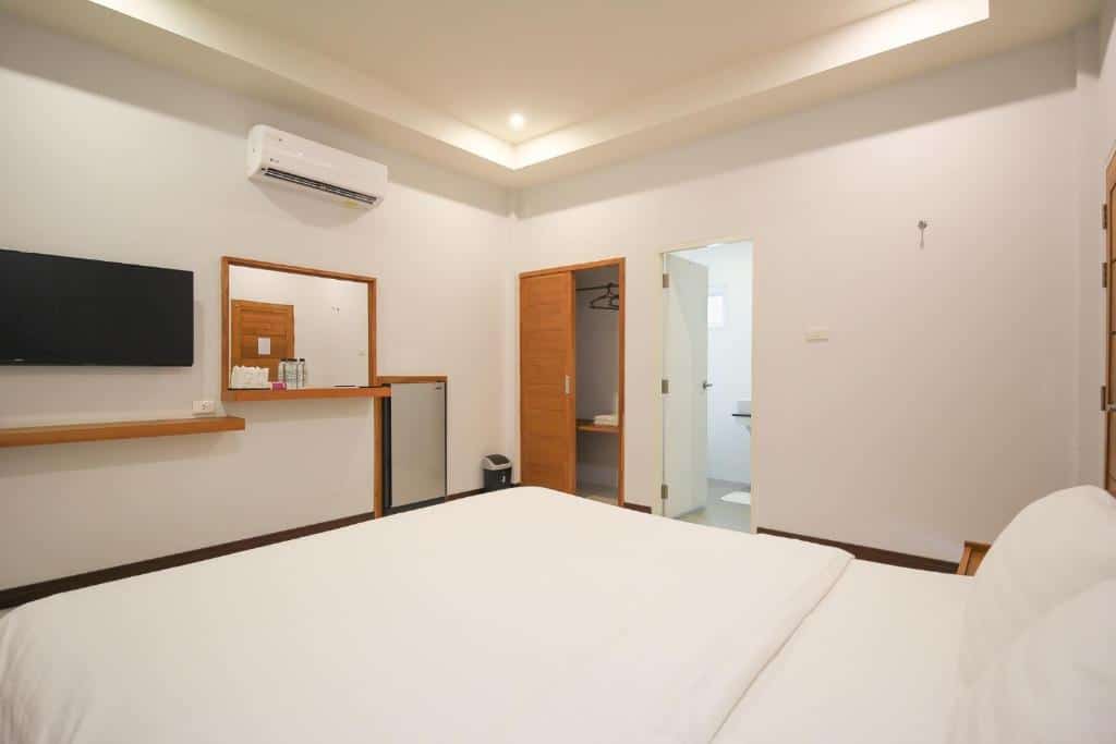 ห้องพักในโรงแรมที่เรียบหรูและเรียบง่ายพร้อมเตียงขนาดใหญ่ ทีวีติดผนัง และห้องน้ำในตัว เหมาะสำหรับผู้ที่กำลังมองหาที่น่าเที่ยว ที่พักเกาะแสมสาร