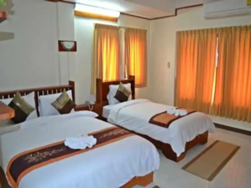 ห้องพักธรรมดาๆ ในโรงแรม มีเตียงคู่ ผ้าม่านสีส้ม และตั้งอยู่ในคำสั่งริมโขงมุกดาหาร. ที่พักริมโขงมุกดาหาร