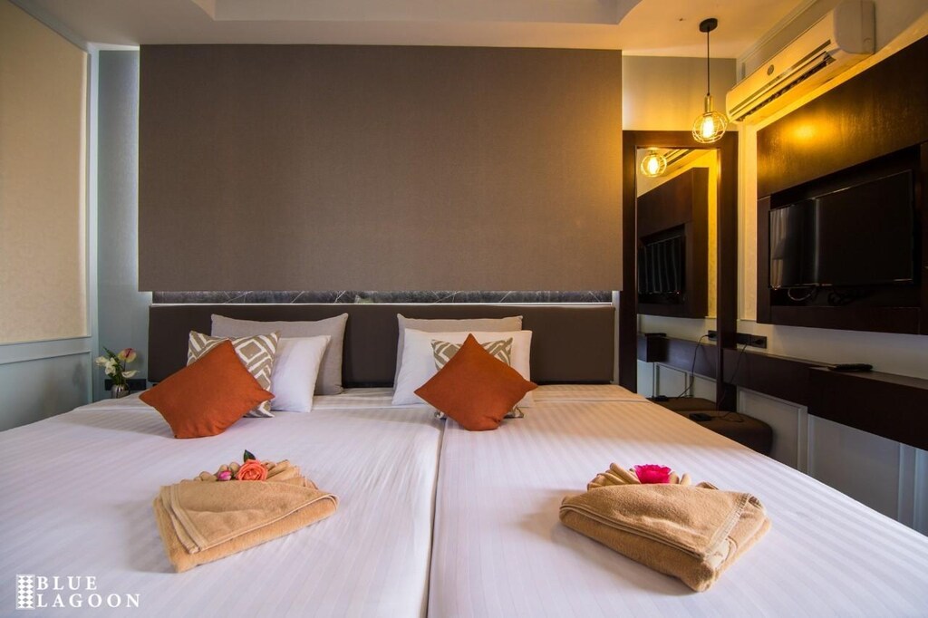 ห้องพักโรงแรมทันสมัยในเมืองเชียงรายพร้อมเตียงแฝด หมอนสำเนียง และทีวีจอแบนบนผนัง ที่พักเชียงรายในเมือง