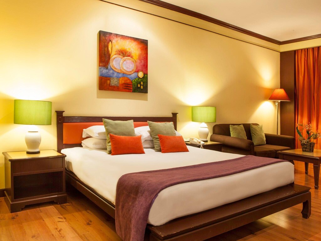ห้องพักในโรงแรมแสนสบายพร้อมเตียงที่จัดอย่างประณีต แสงไฟอันอบอุ่น และงานศิลปะในการตกแต่ง ที่พักมวกเหล็กสระบุรี