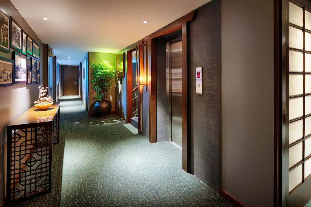 ทางเดินในโรงแรมที่สว่างไสวอย่างอบอุ่นมีประตูบานเลื่อนและการตกแต่งแบบญี่ปุ่นดั้งเดิม โฮจิมินห์ที่เที่ยว
