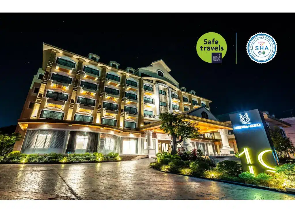 ด้านหน้าของโรงแรมสว่างไสวในเวลากลางคืนพร้อมการแสดงการเดินทางที่ปลอดภัยและการรับรอง SHA, ทาร์ริมโขงดามุกหาร. ที่พักริมโขงมุกดาหาร