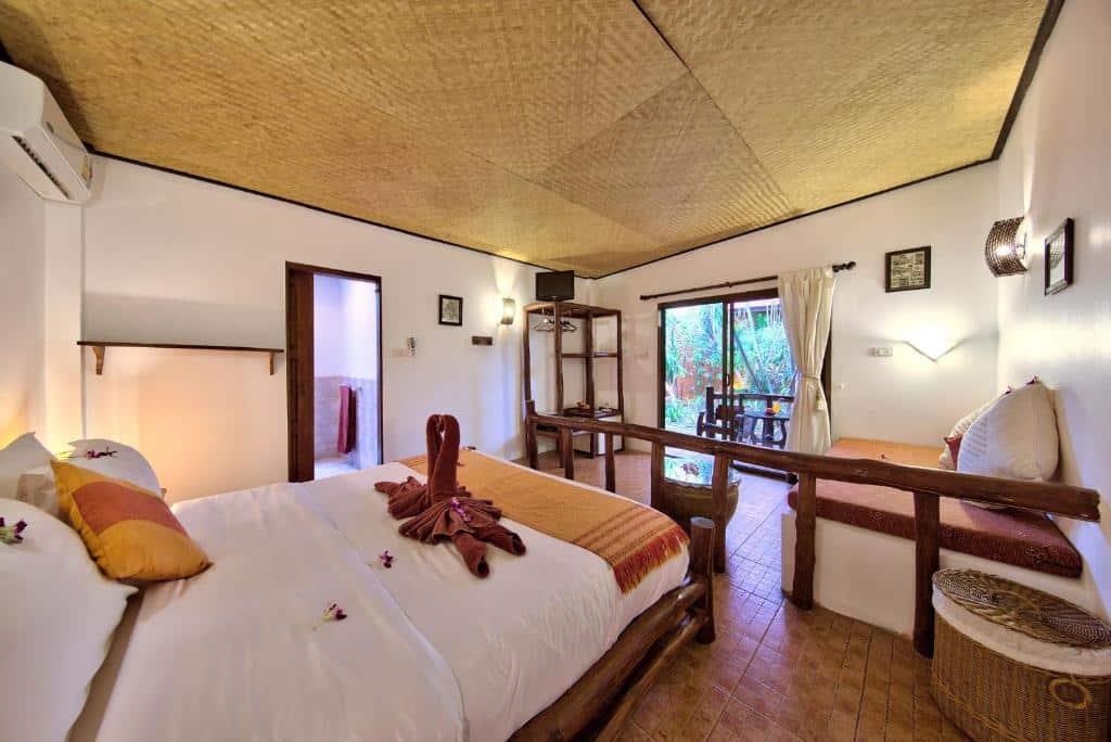 ห้องนอนสไตล์เขตร้อนแสนสบายพร้อมเตียงแฝด เฟอร์นิเจอร์ไม้ และเครื่องปรับอากาศ ที่เที่ยวเกาะสมุย