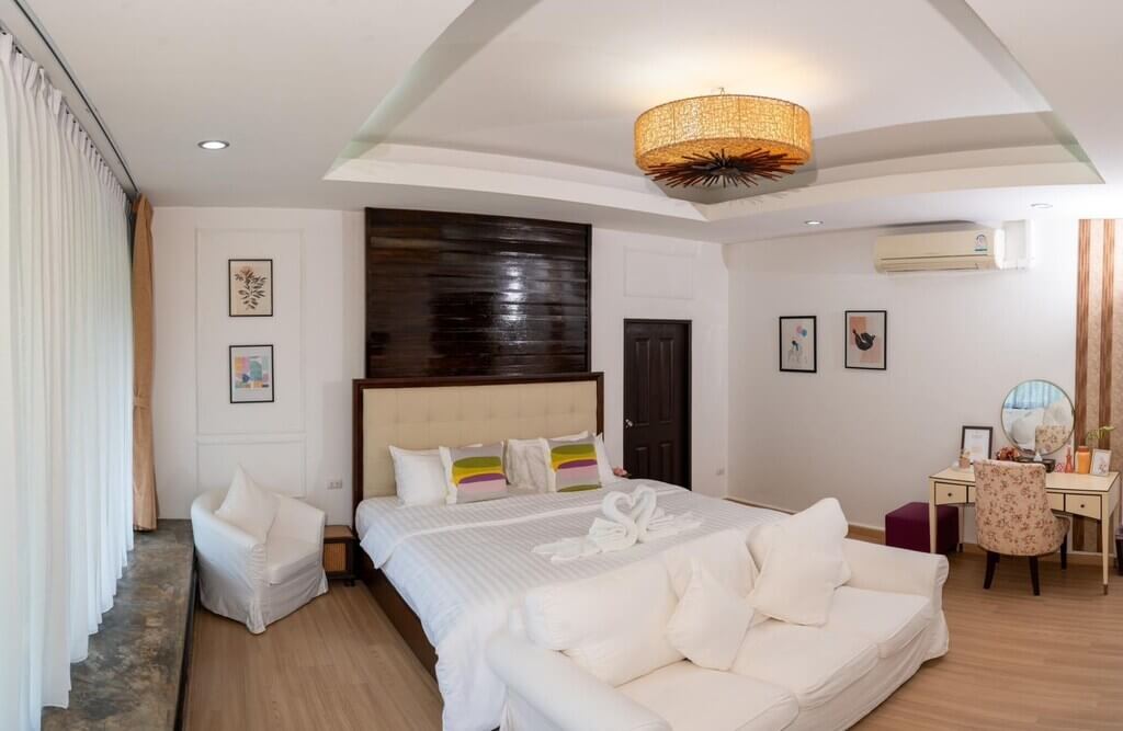 ห้องนอนพร้อมเตียงสีขาวและพัดลมเพดานในเชียงราย ที่พักเชียงรายบนดอย