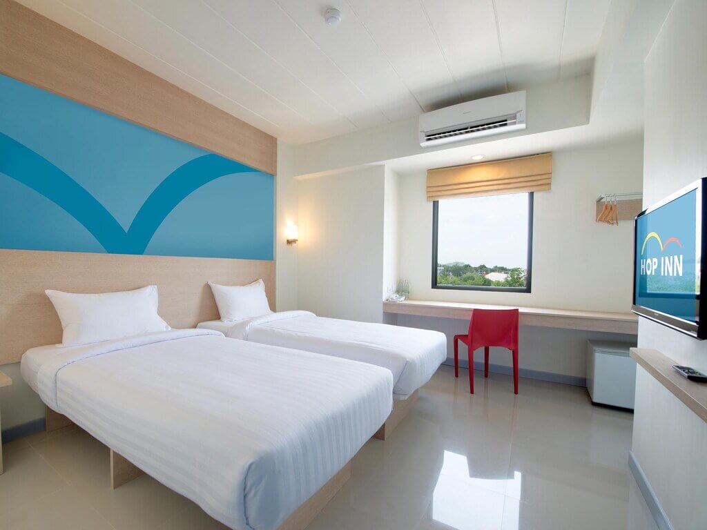 ห้องพักในโรงแรมที่มีเตียง 2 เตียงและโทรทัศน์ที่อยู่บนเนินเขาในจังหวัดเชียงราย ที่พักเชียงรายบนดอย