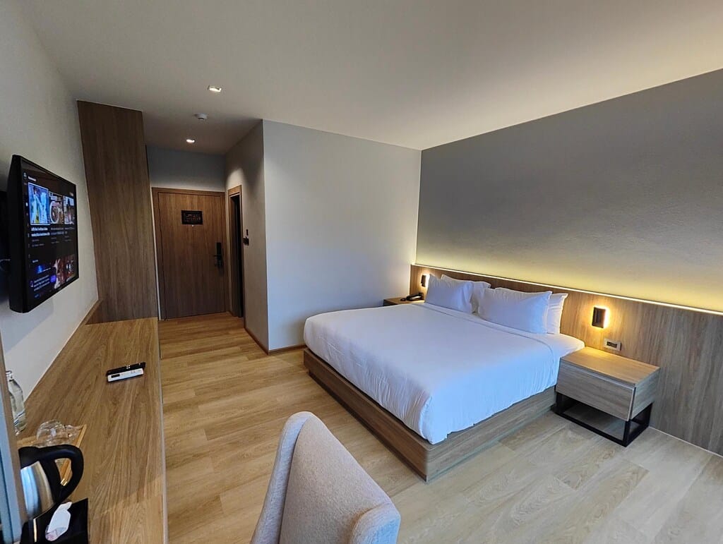 ห้องพักในโรงแรมทันสมัยพร้อมเตียงขนาดใหญ่ โทรทัศน์ติดผนัง และการตกแต่งแบบเรียบง่าย ที่พักเบตง