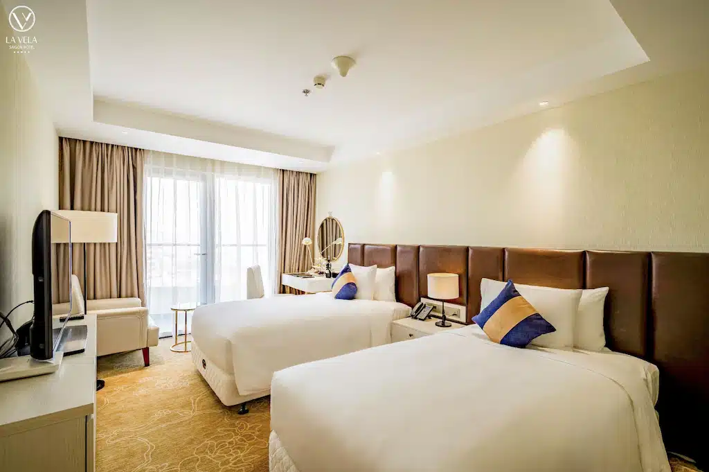 ห้องพักในโรงแรมที่สว่างและทันสมัยในเที่ยวท่องเที่ยวที่มีเตียงคู่ 2 เตียงและเฟอร์นิเจอร์ร่วมสมัย เที่ยวโฮจิมินห์