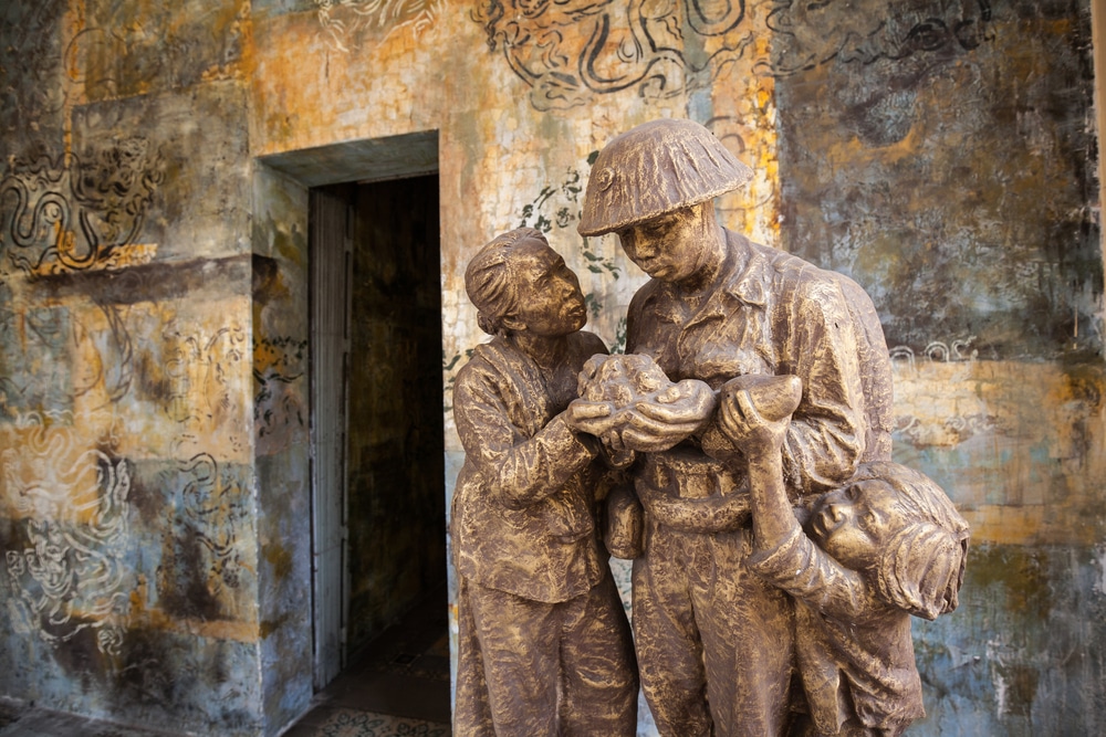 รูปปั้นทองสัมฤทธิ์ของทหารที่กำลังกลับบ้านพร้อมกับเด็กที่คอยต้อนรับอยู่นอกประตูทางเข้าแบบชนบท โฮจิมินห์ที่เที่ยว ซึ่งเป็นภาพที่โดดเด่นในโฮจิมินห์ซิตี้