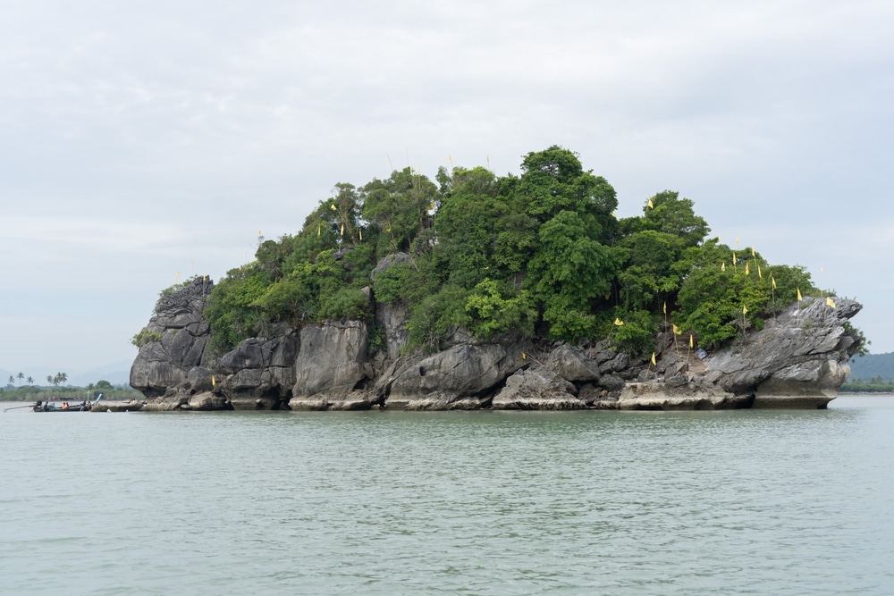 เกาะที่มีต้นไม้เขียวขจีและมีหน้าผาหินโผล่ขึ้นมาจากทะเล ที่เที่ยวขนอม