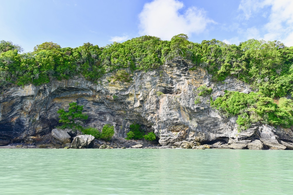หน้าผาหินปูนเขียวขจีริมทะเลสีฟ้าครามใต้ท้องฟ้าสีครามสดใส ที่เที่ยวขนอม