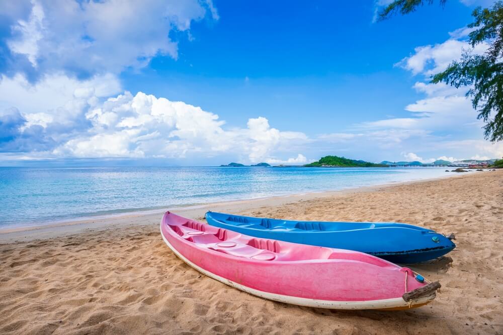 เรือแคนูสีชมพูและสีฟ้าสองลำบนหาดทราย ทะเลสัตหีบ