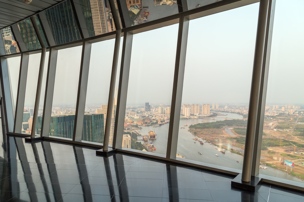 วิวแม่น้ำและทิวทัศน์เมืองผ่านหน้าต่างมุมบานใหญ่จากอาคารสูงในโฮจิมินห์ซิตี้ โฮจิมินห์ที่เที่ยว
