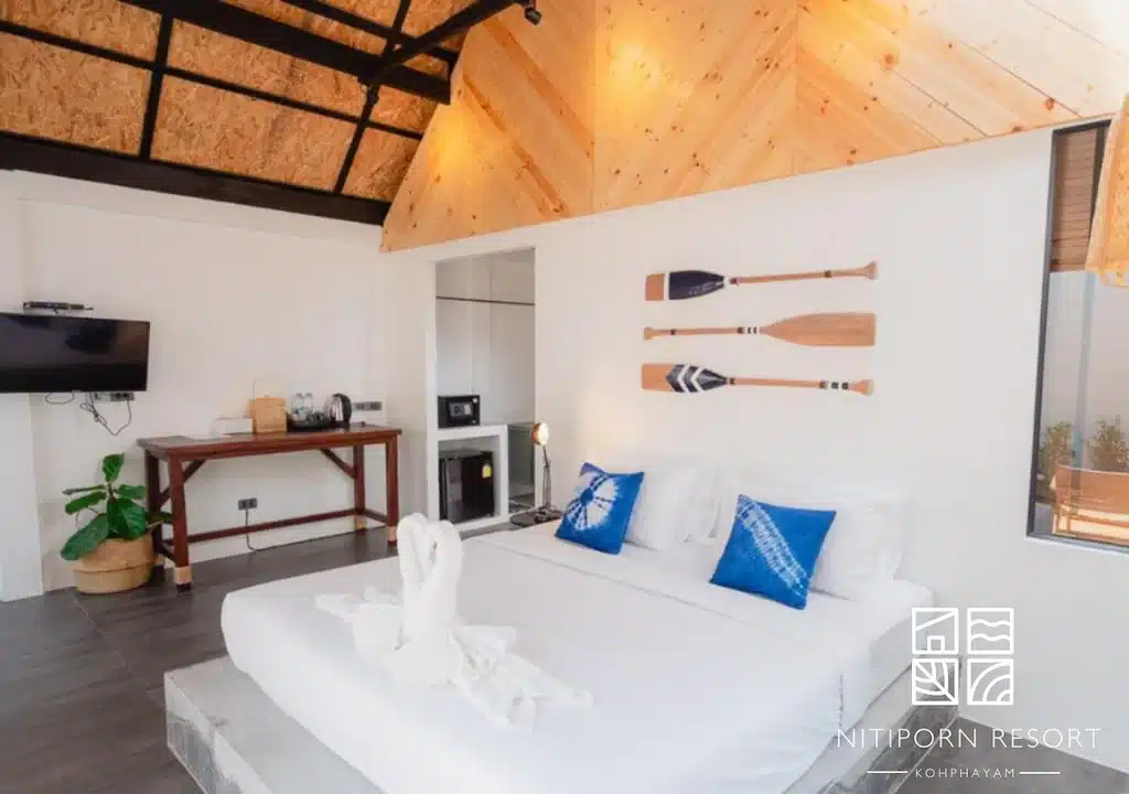 ห้องนอนสว่างสดใสทันสมัยที่บลูสกายรีสอร์ทเกาะพยามพร้อมเตียงสีขาว เพดานไม้ ไม้พายประดับ ที่พักเกาะพยาม