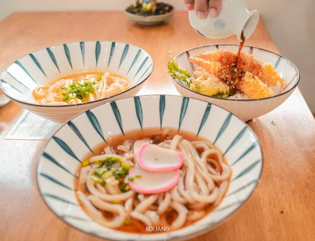 คนราดซอสบนจานข้าวพร้อมซุปอุด้งและบะหมี่รสเผ็ดอีกชามที่ร้านอาหารญี่ปุ่น  ร้านอาหารญี่ปุ่นภูเก็ต