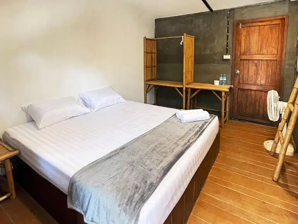ห้องพักสไตล์มินิมอลที่เดอะบลูสกายรีสอร์ท ที่พักเกาะพยาม เกาะพยาม มีเตียงคู่พร้อมชุดเครื่องนอนสีขาว