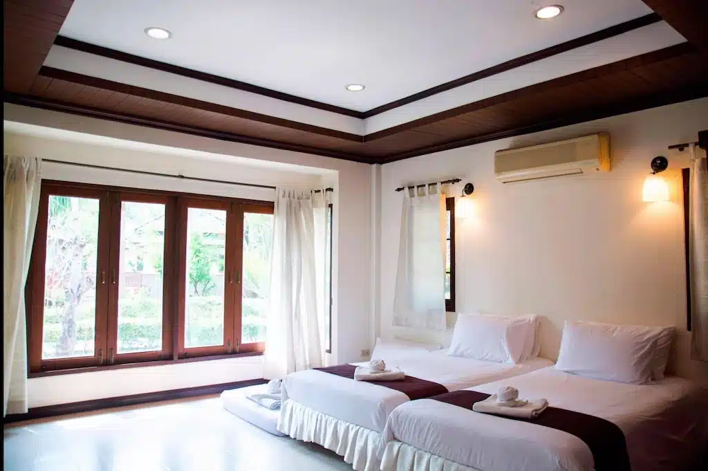 ห้องพักสว่างสดใสกว้างขวาง โรงแรมตาก มี 2 เตียง ที่พักตาก ผ้าปูที่นอนสีขาว หน้าต่างบานใหญ่พร้อมผ้าม่าน และแสงไฟทันสมัย