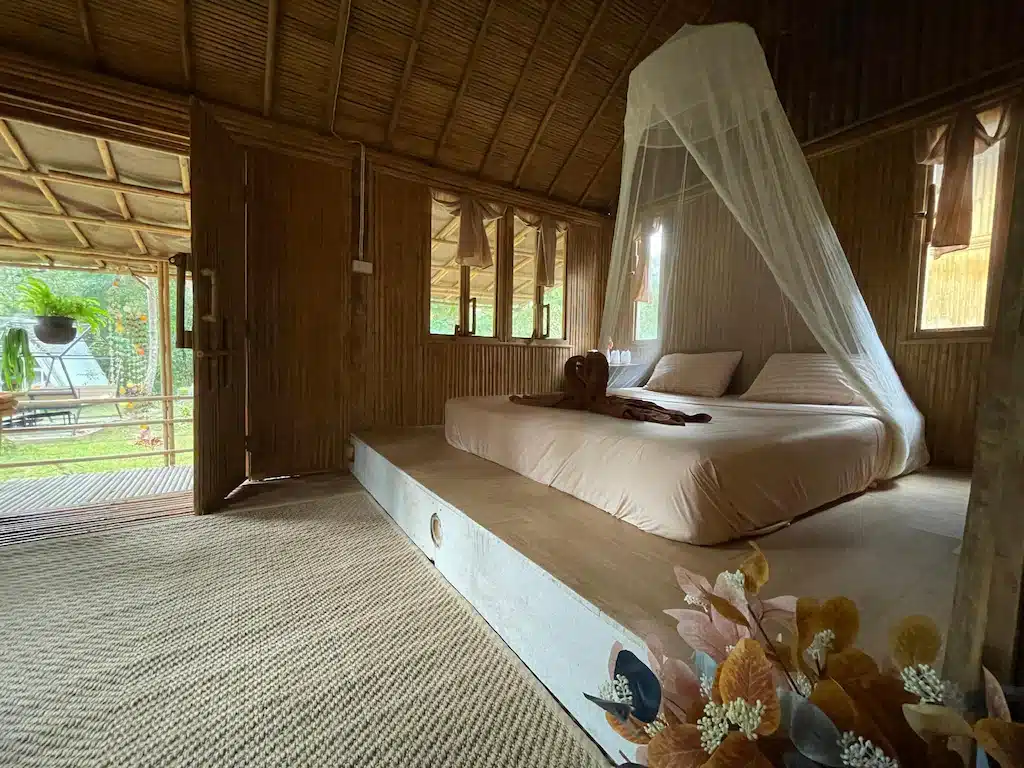 ภายในกระท่อมไม้ไผ่ที่บลูสกายรีสอร์ทเกาะพยามพร้อมเตียงไม้ขนาดใหญ่ปู ที่พักเกาะพยาม ด้วยมุ้งกันยุง