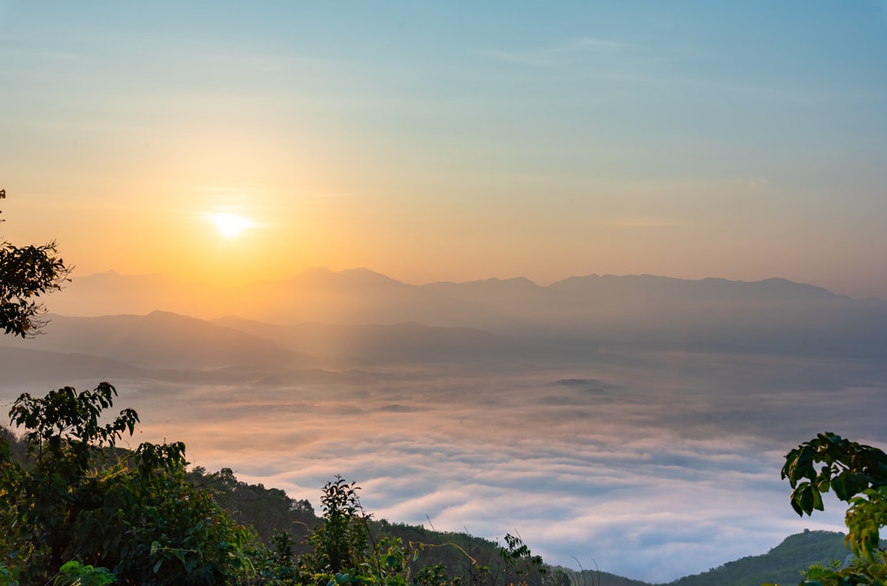 พระอาทิตย์ขึ้นเหนือเทือกเขาทะเลหมอกที่ปกคลุมไปด้วยท้องฟ้าสีครามสดใส แนะนำ จุดชมวิว ทะเลหมอก ประเทศไทยสุดว๊าววว ทะเลหมอกยามเช้า อากาศดี บรรยากา
