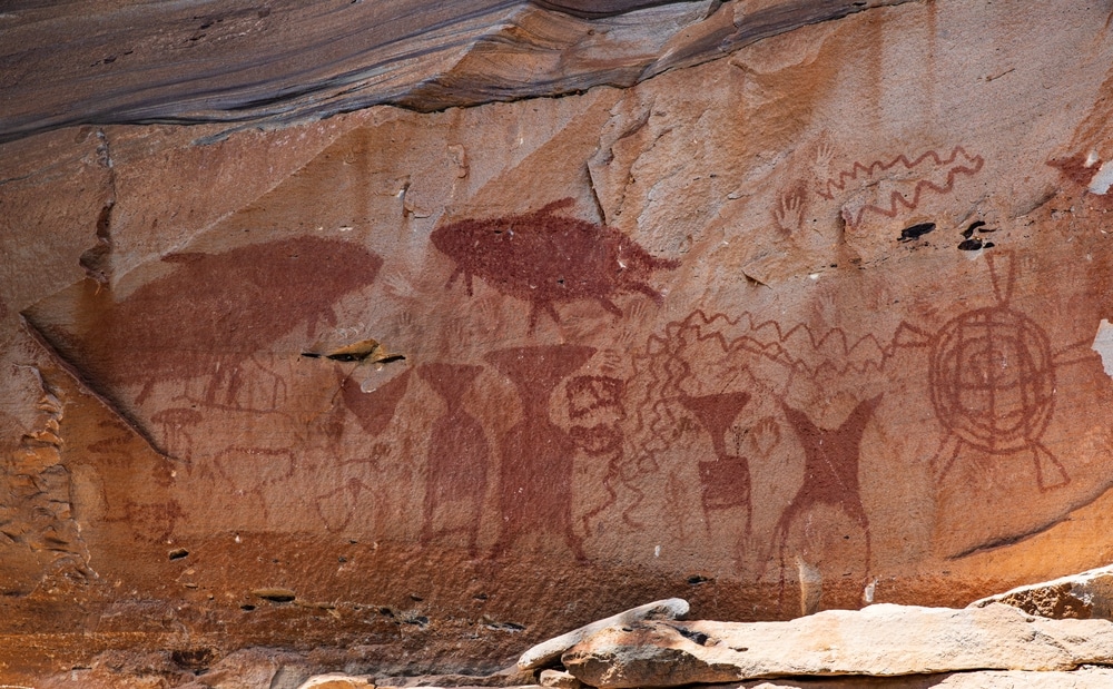 ศิลปะหินโบราณที่แสดงภาพบุคคลต่างๆ ทั้งสัตว์ และรูปทรงเรขาคณิต บนพื้นผิวหินสีน้ำตาลแดงในภาคตะวันออกเฉียงเหนือของประเทศไท ท่องเที่ยวภาคอีสาน