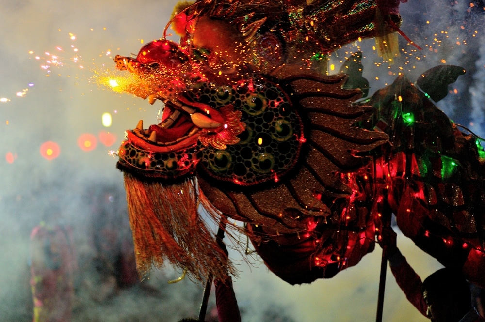 ชุดมังกรหลากสีสันมีประกายไฟปลิวออกจากปากในช่วงเทศกาล งานตรุษจีน แบบดั้งเดิม