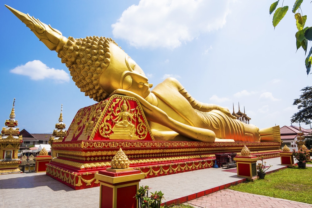 พระพุทธไสยาสน์ทองคำขนาดใหญ่ ณ วัดราชบุรี ใต้ท้องฟ้าสีครามสดใส ที่เที่ยวหลวงพระบาง 