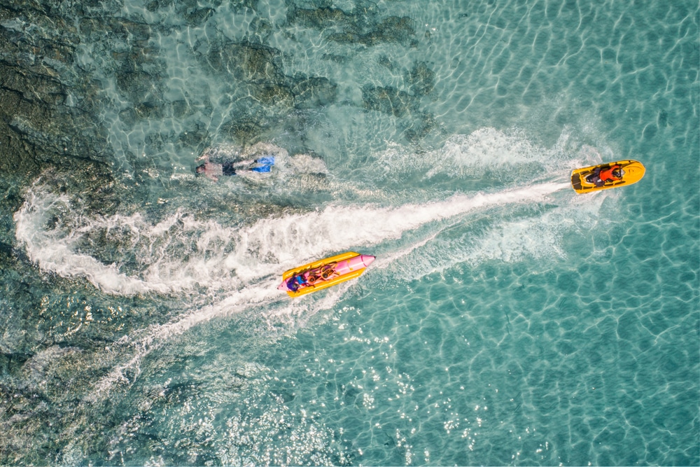 เรือส่วนตัว 2 ลำแล่นอยู่ใกล้นักว่ายน้ำในน้ำทะเลสีฟ้าครามใส ที่เที่ยวสาธารณะ ที่เที่ยวเดือนกันยายน