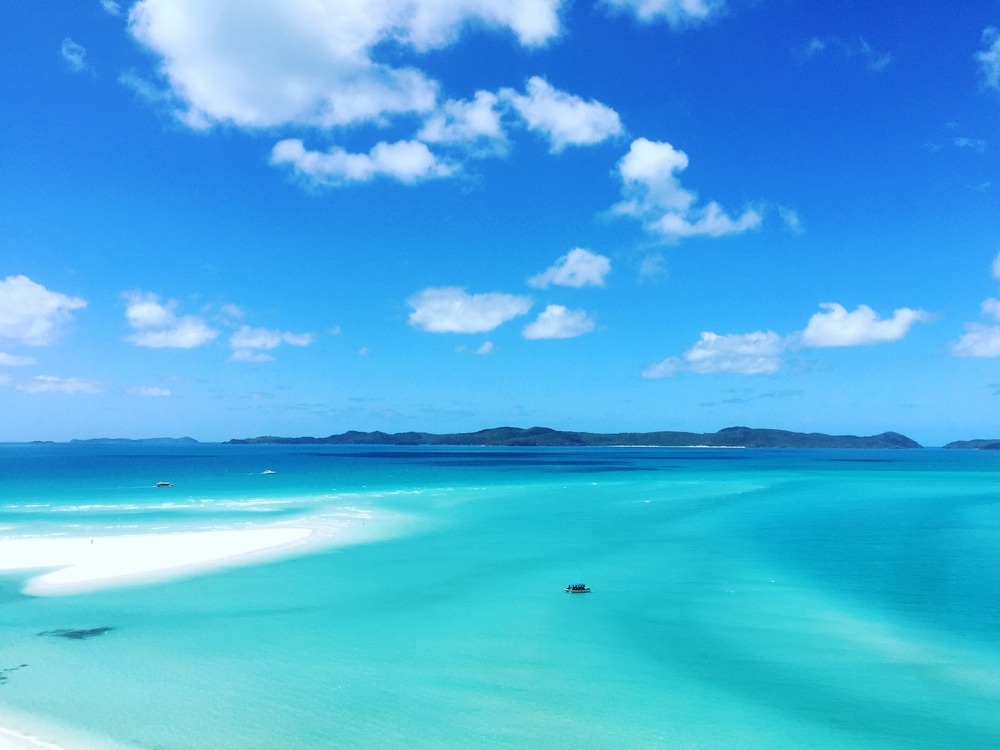 ทิวทัศน์มุมกว้างของท้องทะเลสีฟ้าคราม ท้องฟ้าสีฟ้าใส เมฆปุย เกาะที่สวยที่สุดในโลก และเกาะในประเทศในโลก โดยมี