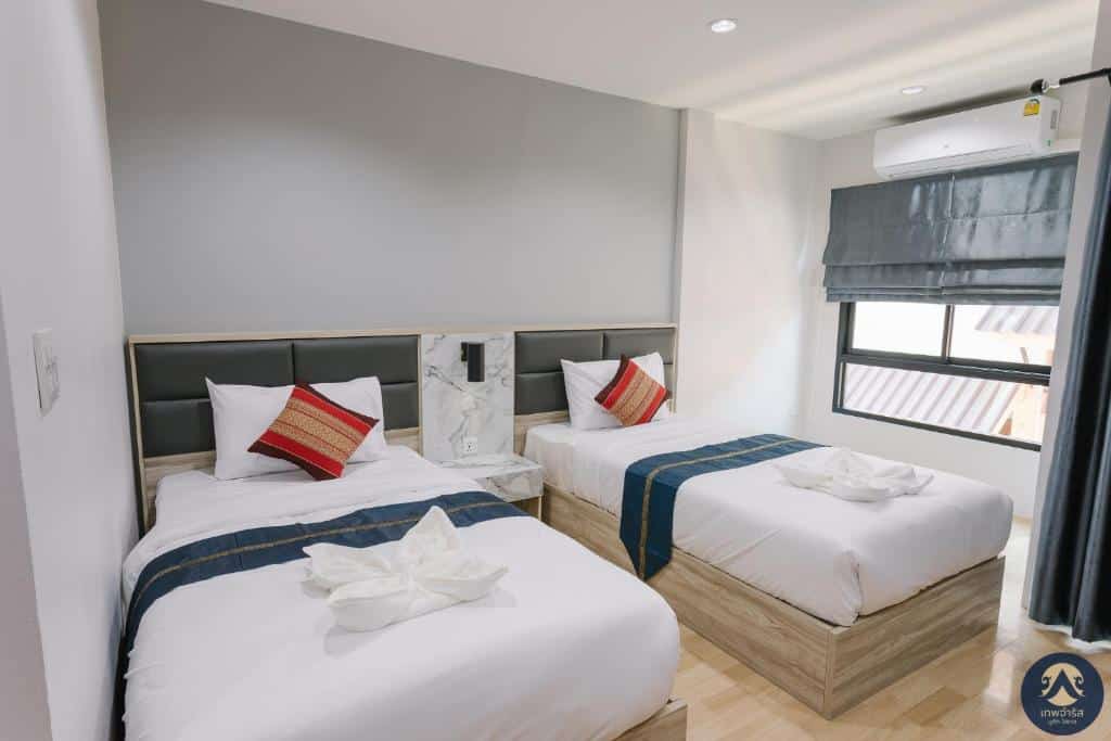 ห้องพักโรงแรมทันสมัยในอุตรดิตถ์ มีเตียงแฝด 2 เตียง หัวเตียงสีเทา ที่พักอุตรดิตถ์ในเมือง ห้องสวย  หมอนเน้นสีแดง และหน้าต่างพร้อมมู่ลี่