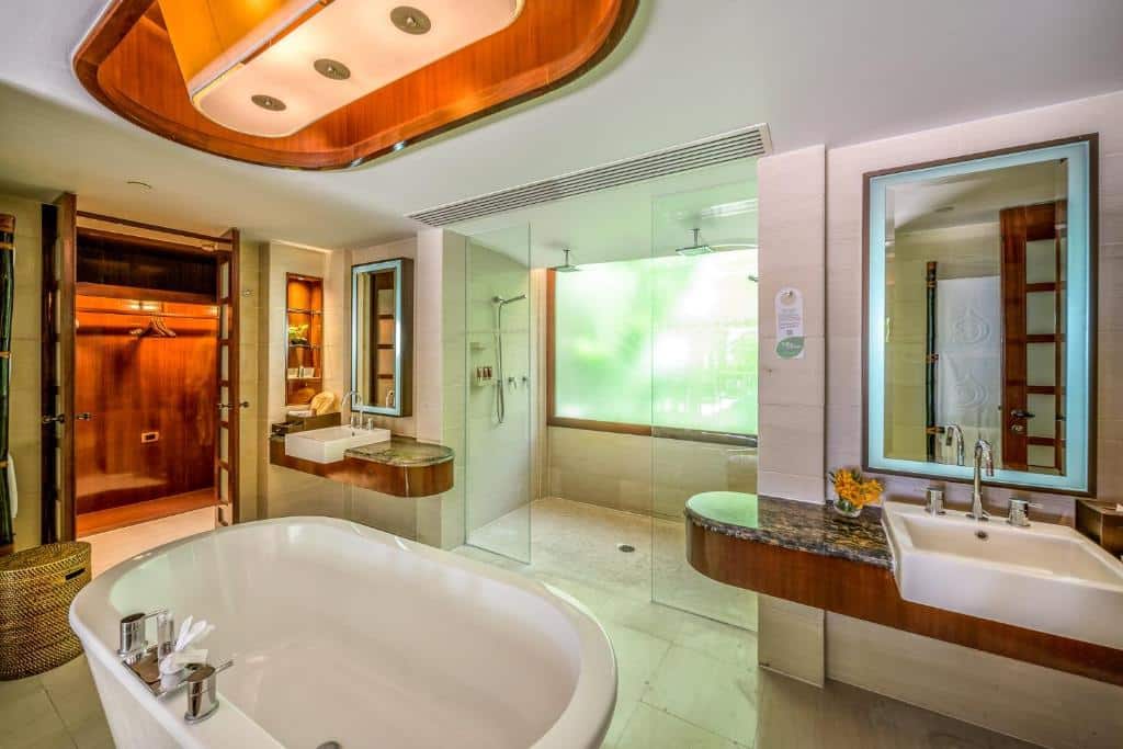 ภายในห้องน้ำที่หรูหราประกอบด้วยอ่างอาบน้ำ พื้นที่ฝักบัวแบบวอล์กอิน อ่างล้างหน้าคู่ และห้องซาวน่าสไตล์เกาะพีพีตกแต่งด้วยไม้ เกาะห้อง