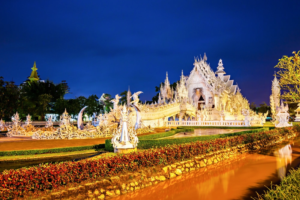 วัดสีขาวที่สว่างไสวและออกแบบอย่างประณีตตั้งตระหง่านท่ามกลางท้องฟ้าสีคราม ล้อมรอบด้วยสวนที่ได้รับการดูแลอย่างดีและทางน้ำขนาดเล็ก ทำให้ที่นี่เป็นหนึ่งในไฮไลท์ในรายชื่อ 10 สถานที่ท่องเที่ยวเชียงราย