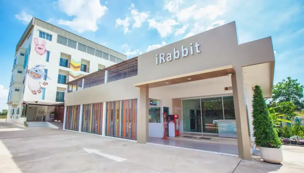 อาคารทันสมัยพร้อมป้าย "iRabbit" ซึ่งมีส่วนหน้าอาคารและบริเวณทางเข้าสีสันสดใส การทาสีบนผนังที่อยู่ติดกันมีตัวการ์ตูนด้วย -