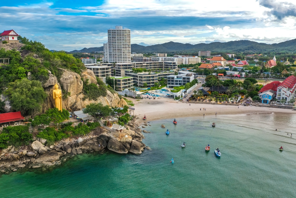 สถานที่ฮันนีมูนในไทย มุมมองทางอากาศของเมืองชายฝั่งที่มีหาดทราย เรือหลายลำอยู่ในน้ำ อาคารสมัยใหม่ และพระพุทธรูปทองคำองค์ใหญ่บนไหล่หิน นับเป็นความงดงามตระการตาของฮอนีมูนในไทยอย่างแท้จริง