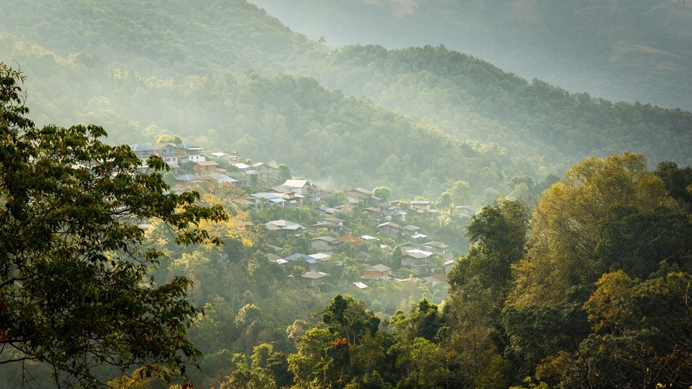 หมู่บ้านเล็กๆ ที่มีบ้านเรือนตั้งอยู่ท่ามกลางหุบเขาที่เขียวชอุ่มไปด้วยป่าอันเขียวขจี และมีภูเขาดอยภาคเหนือที่มีหมอกหนาเป็นฉากหลัง ดอยภาคเหนือ