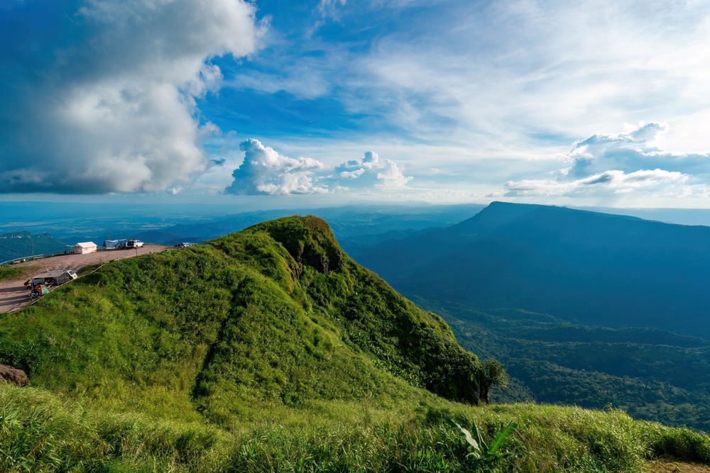    สถานที่ฮันนีมูนในไทย     ทิวทัศน์ภูเขาเขียวชอุ่มใต้ท้องฟ้ามีเมฆบางส่วน มียานพาหนะหลายคันและผู้คนมองเห็นได้บนพื้นราบทางด้านซ้าย ภูมิทัศน์อันเงียบสงบนี้สามารถเป็นสองเท่าของพื้นที่ฮันนีมูนในไทย นำเสนอความเงียบสงบและความงามตามธรรมชาติ